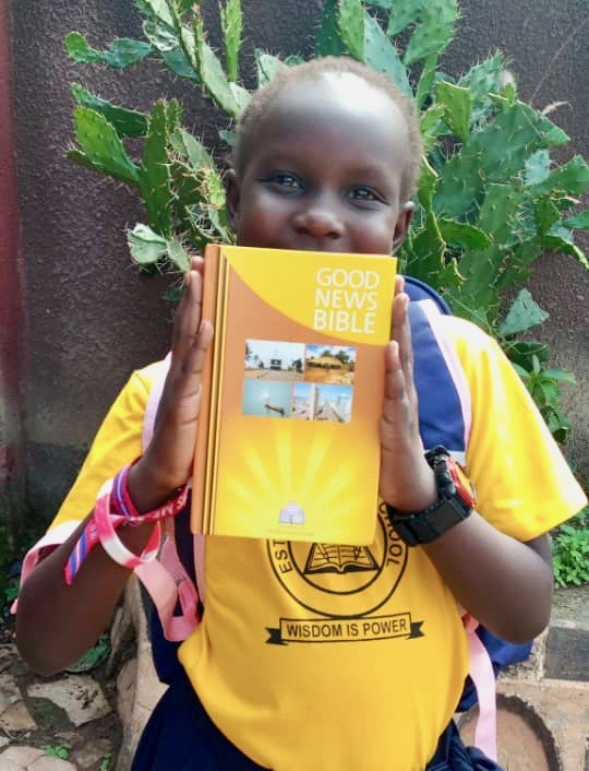 Child holding a Good News Bible